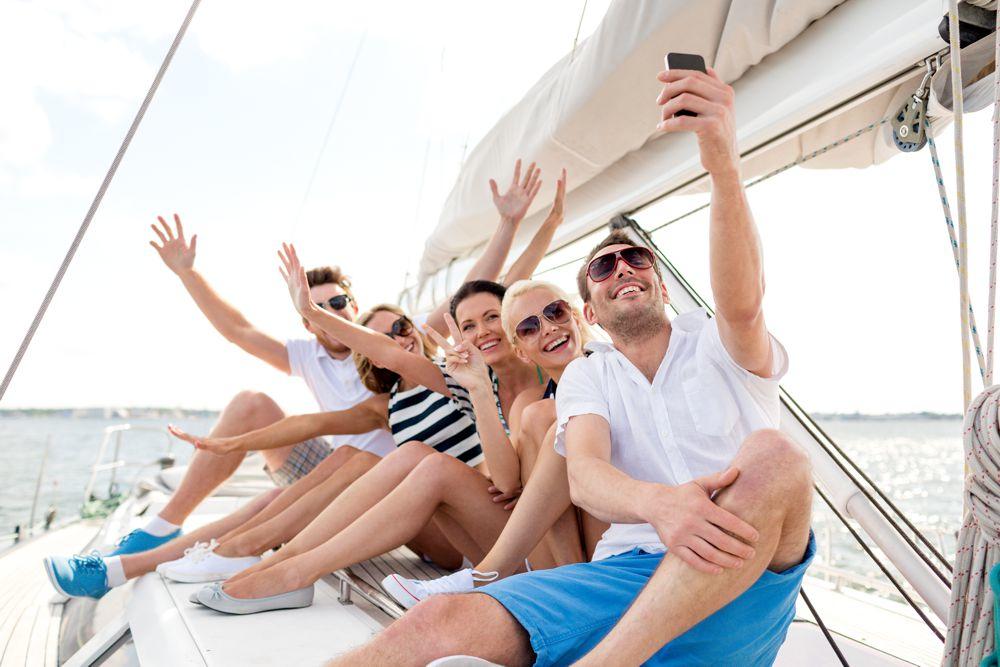 Credito per la barca diverse persone che salutano e scattano un selfie